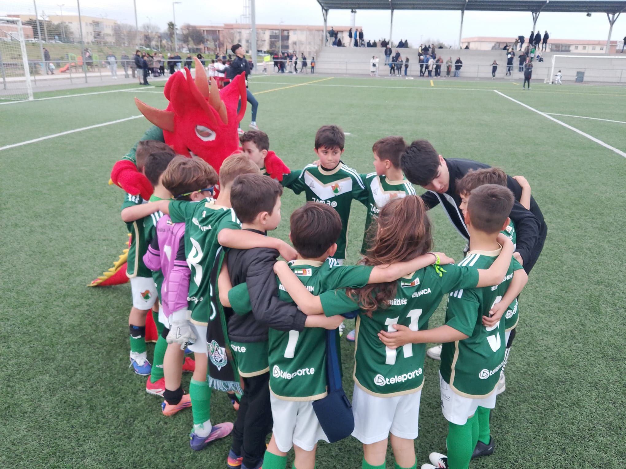 Dragoncito acompaña al Cacereño en un partido de fútbol base en Cáceres